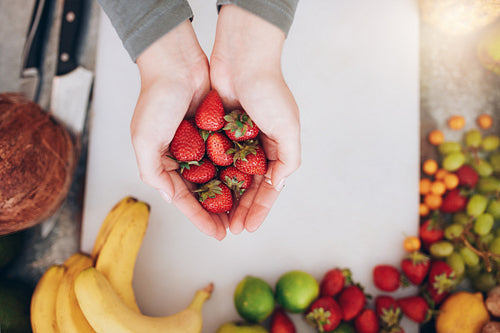 Woman holding a handful of fresh strawberries
