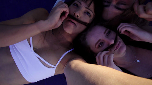 Playful friends taking fun selfies together in a basketball court