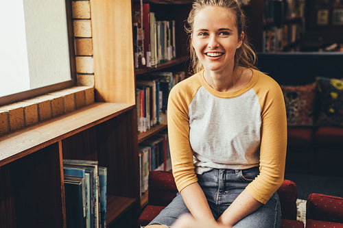 Smiling girl student sitting at school library