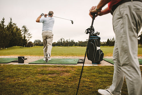 Golfer teeing up at the driving range
