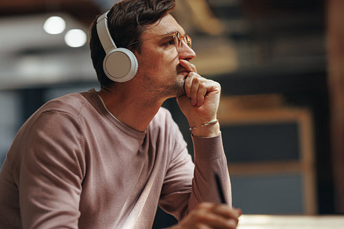 Designer thinking about his project while sitting in a cafe