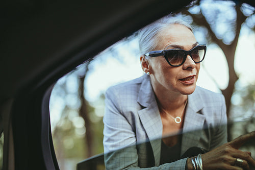 Businesswoman in sunglasses talking with taxi driver