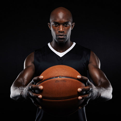 Muscular young basketball player with a ball