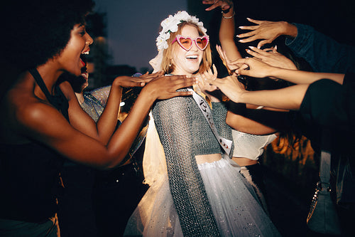 Bride-to-be dancing joyfully at a bachelorette party surrounded by her best friends
