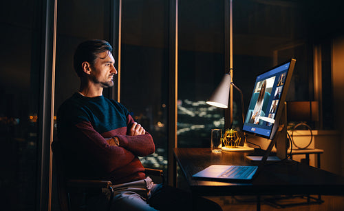 Caucasian entrepreneur having a video conference with his colleagues at night