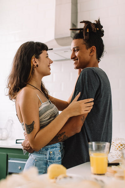 Romantic young couple smiling at each other in the kitchen