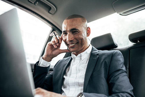 Businessman looking at laptop sitting in car