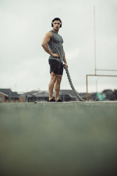Sportsman taking break from battling rope workout.
