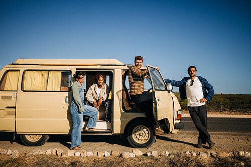 Stretching out: Friends stand beside their van during a road trip stop