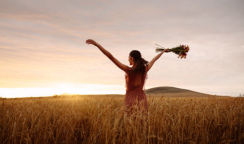 Woman enjoying in countryside at sunset