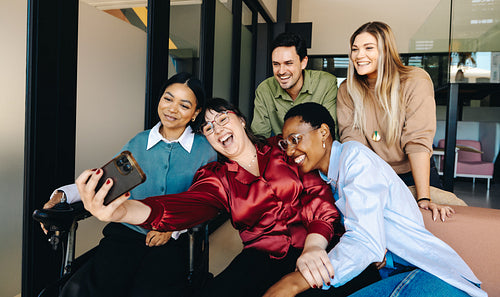 Diverse group of professionals taking a selfie in an office setting