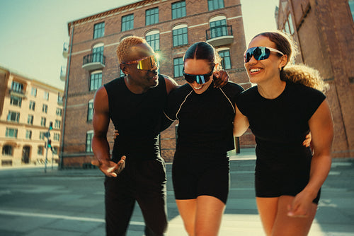 Running club friends walking and laughing in urban setting