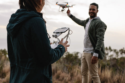 Young couple flying drone in countryside