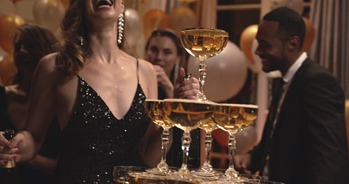 Pyramid of champagne glasses with a woman dancing