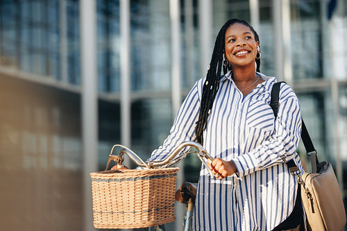 Smiling business woman going to work with a bicycle in the city