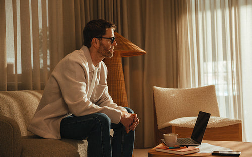 Man focuses on work with laptop and coffee in modern office