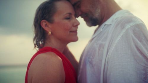 Mature couple enjoying a romantic tropical beach sunset at a luxurious resort