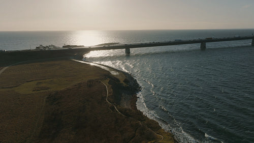 Sunset over the Great Belt Bridge: Traffic taking a majestic journey across Denmark's coastal landscape