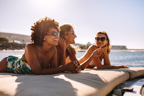 Three young women sunbathing on yacht
