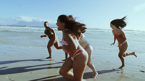 Different sized women running race on beach
