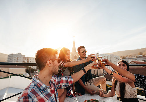 Friends hanging out with drinks on rooftop party