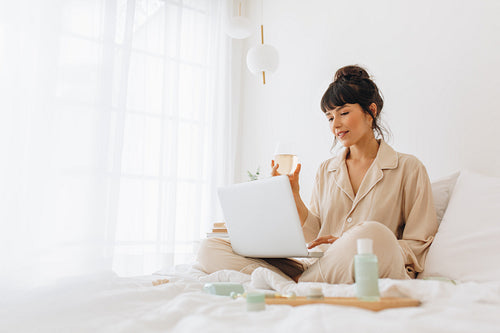Woman working from home enjoying wine and beauty care