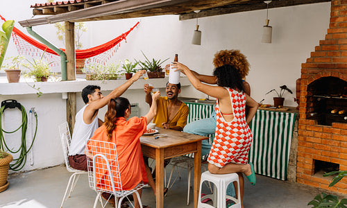 Group of friends toasting at an outdoor gathering with cheerful ambiance