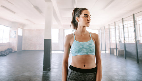 Healthy young woman standing in gym