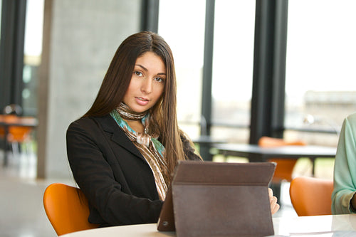 Young female student at library with digital tablet