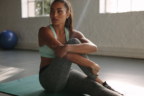 Healthy young female taking rest after training in gym