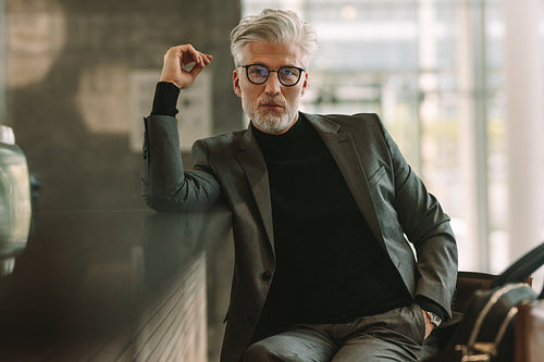 Handsome senior businessman sitting at cafe