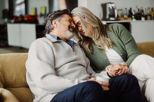 Senior couple relaxes together on sofa at home