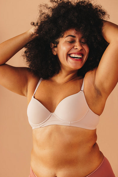 Cheerful plus size woman smiling happily in underwear