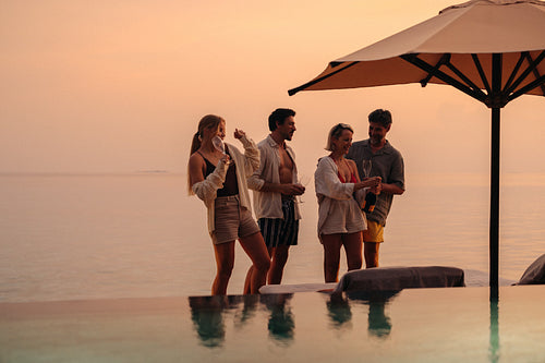 Popping champagne: Family celebrating together at sunset