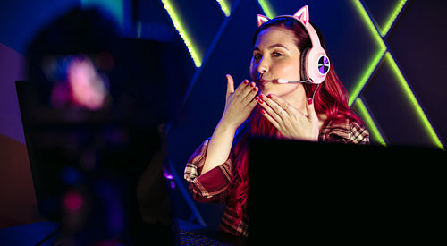 Female blowing a kiss while recording a live stream of her gameplay