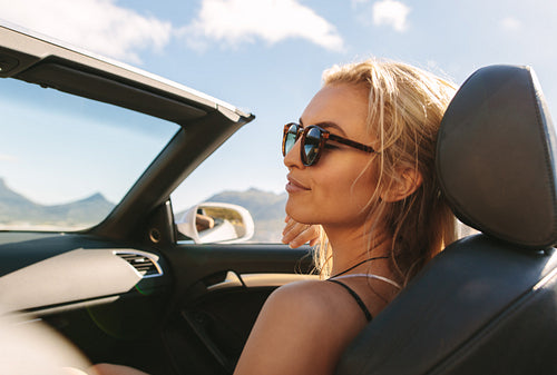 Woman on road trip in convertible car