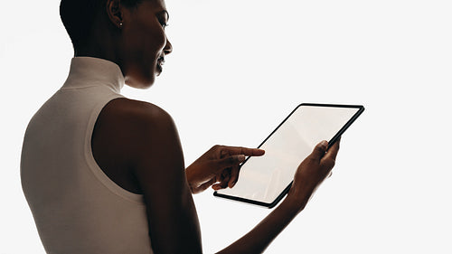 Woman using a digital tablet with a minimalistic background