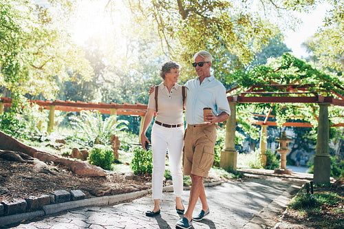Happy senior couple talking a walk in park