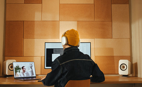 Man wearing headphones joins a video call in office workspace