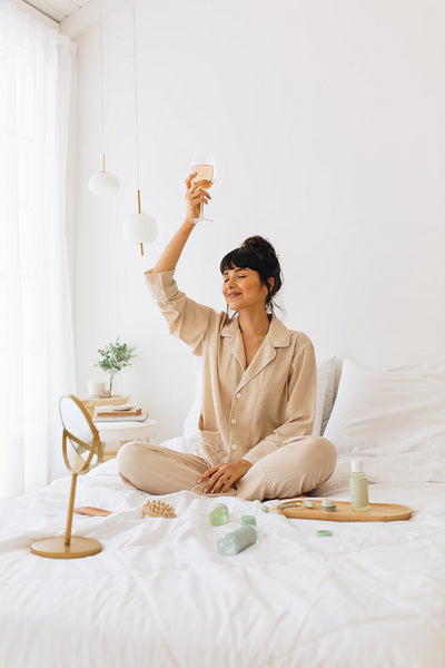 Woman enjoying glass of wine after beauty facial at home