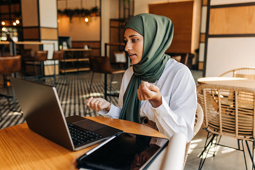 Muslim businesswoman having a video call in a cafe