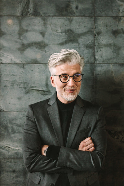 Happy mature businessman standing with arms crossed