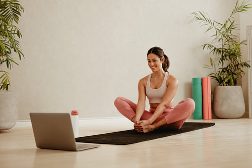 Woman doing exercises at home watching online training
