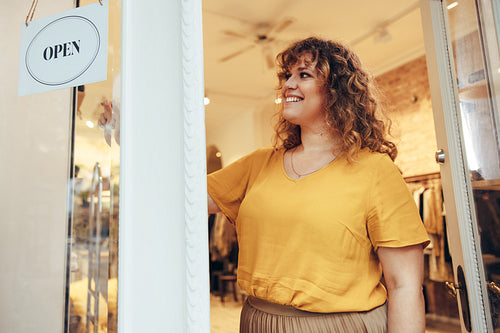 Fashion boutique owner putting OPEN sign on door