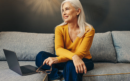 Pensive senior woman working comfortably from home
