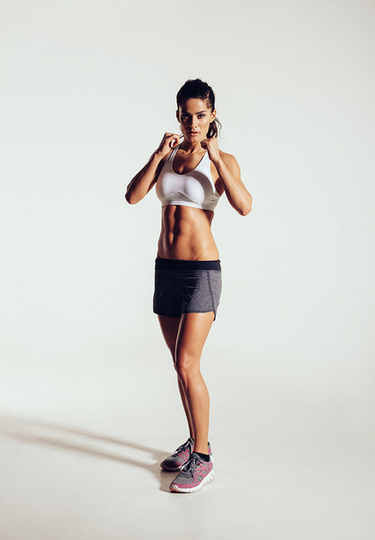 Strong young woman doing boxing exercising in studio