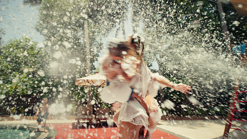Happy family having fun at a foam party at a tropical resort during their summer vacation