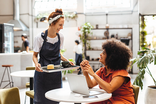 Waitress serving a customer coffee on a tray