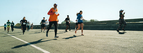 Group of marathon runners competing in sunny outdoor race