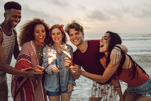 Friends partying on the beach with sparklers